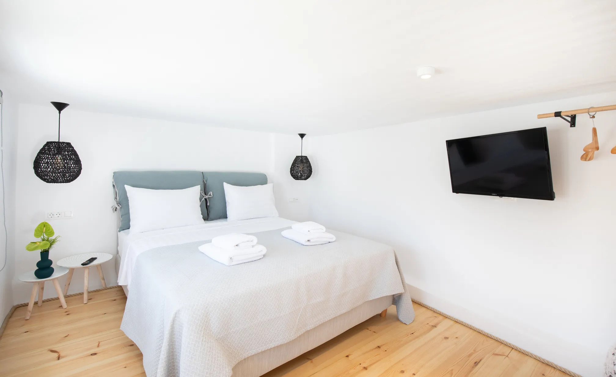 Deluxe Loft Suite · Loft bedroom with black wicker pendant and wooden floor